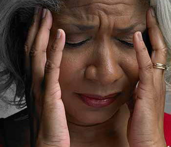 Mature woman with head in hands and eyes closed, close-up